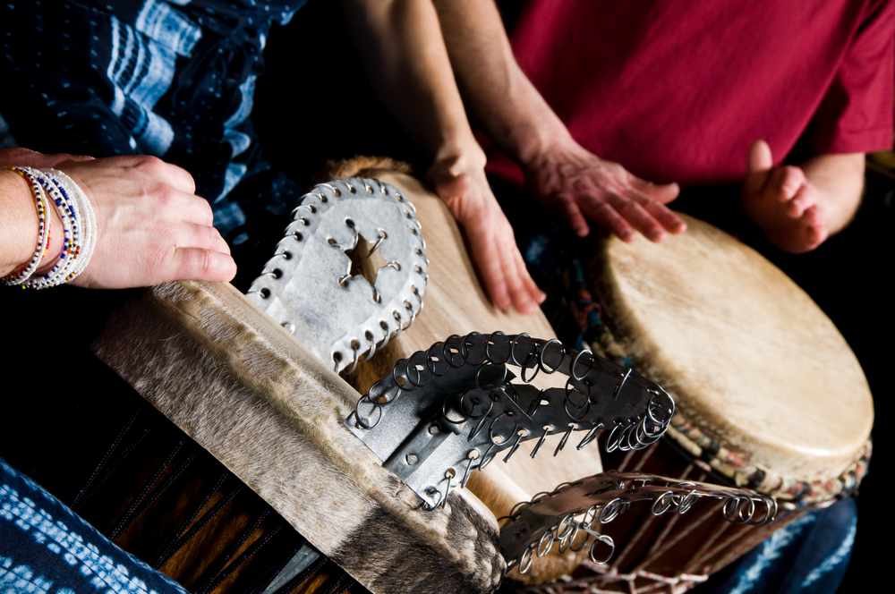 three musicians playing drums in a studio