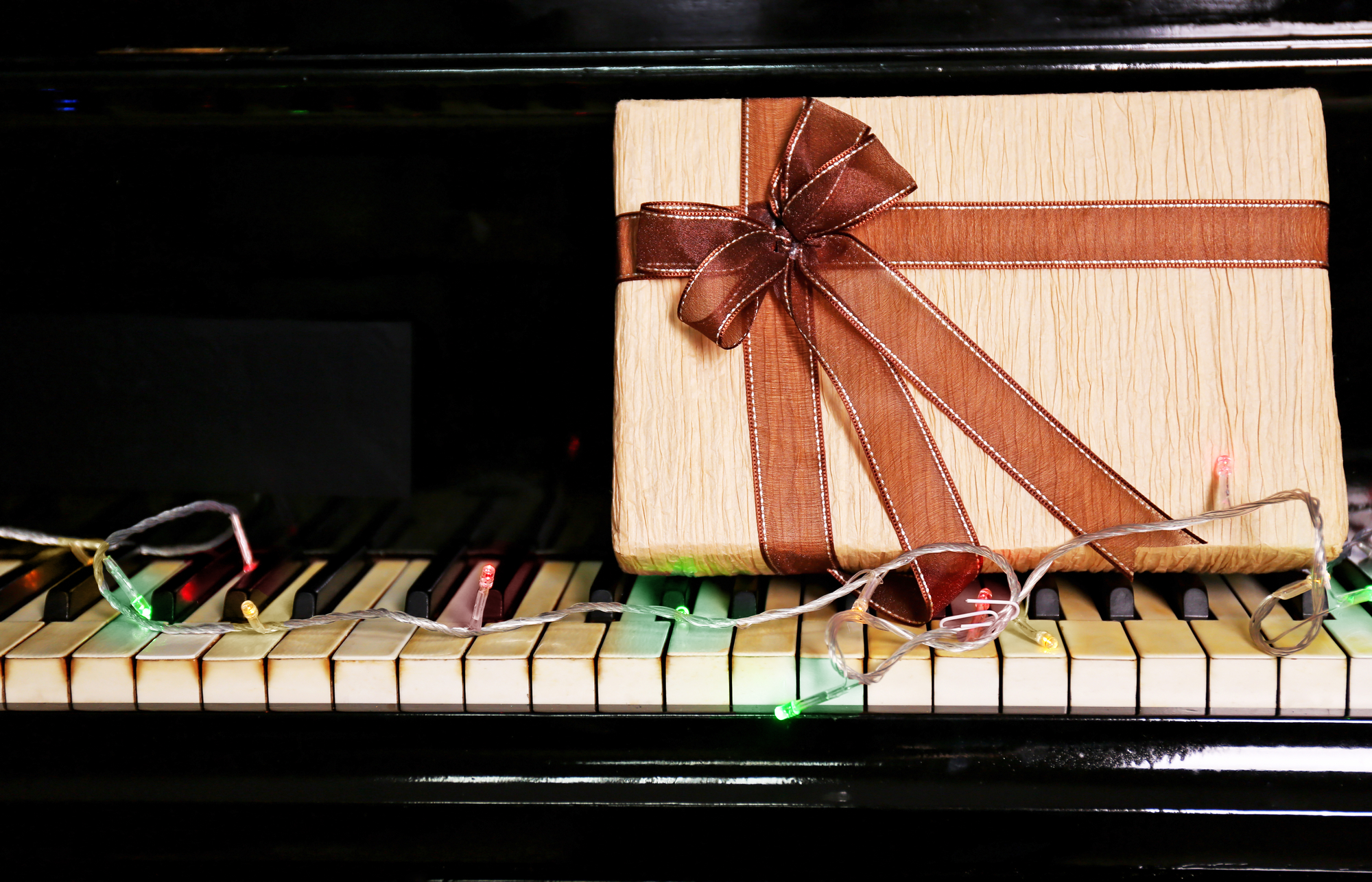 Christmas gift box on piano keys, closeup piano gift guide