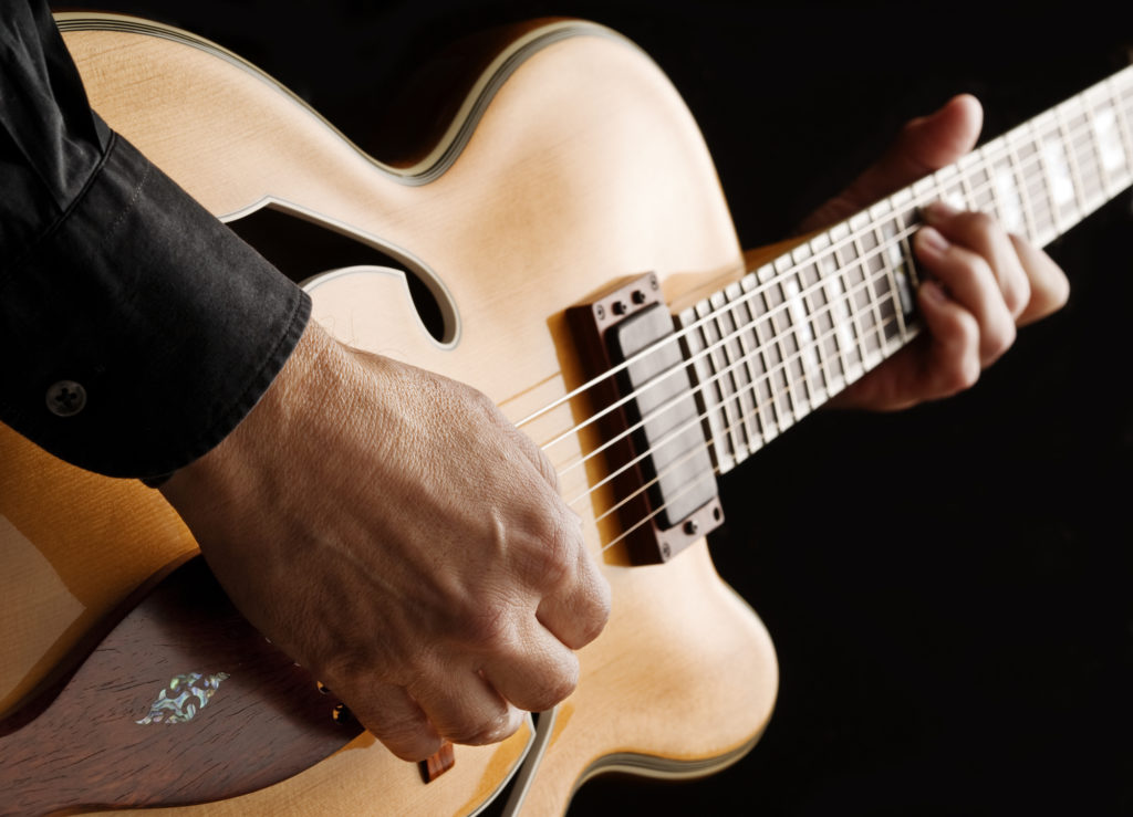 guitarist playing custom made jazz guitar