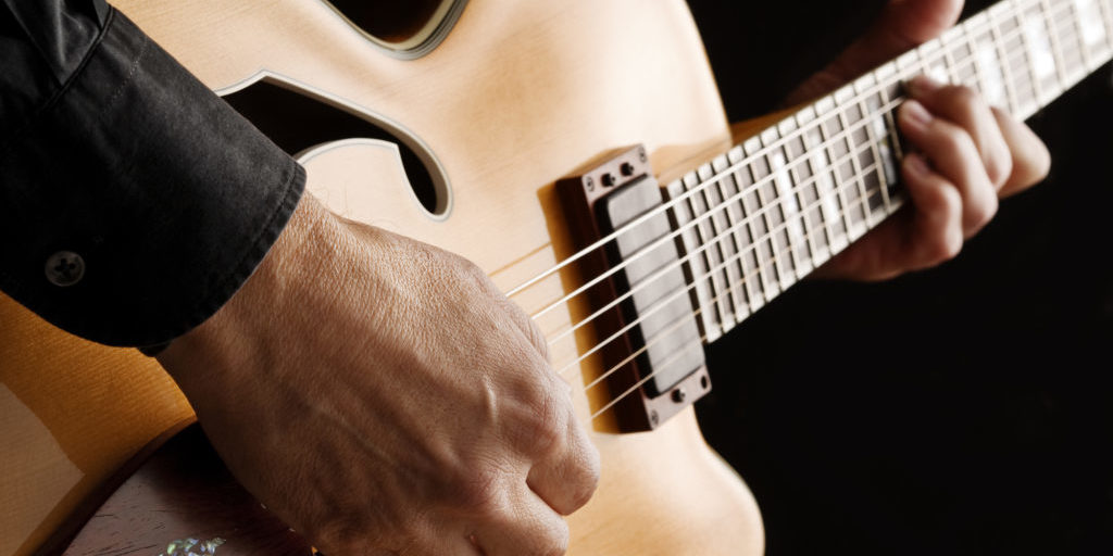 guitarist playing custom made jazz guitar