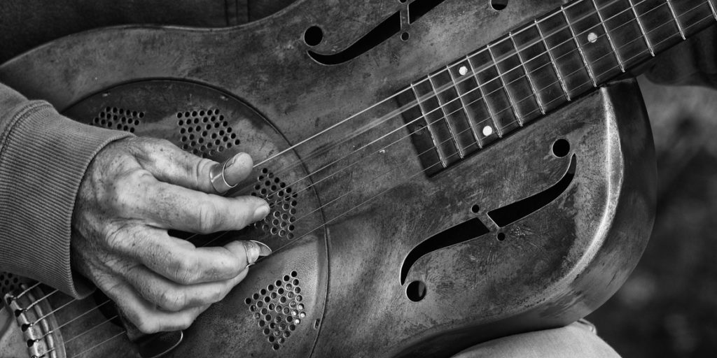 A detail picture of a guitar playing man with a metal - guitar. black abd White high contrast picture