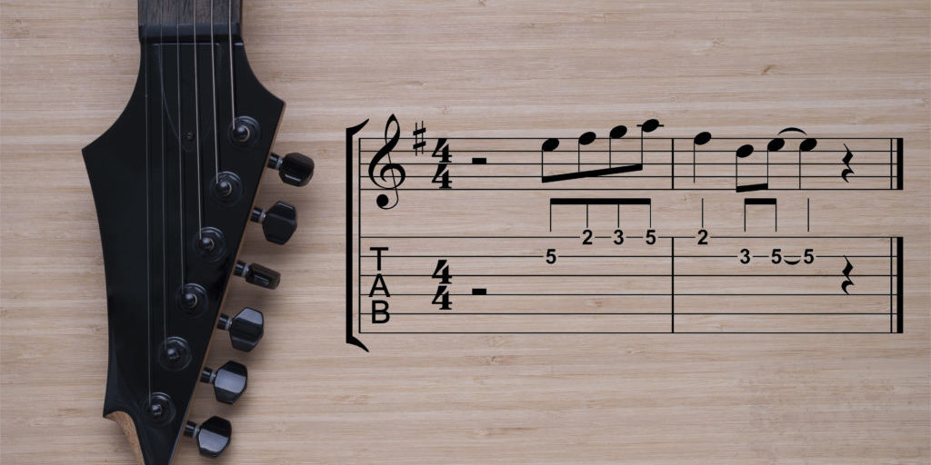 electric guitar fretboard on a wooden background texture