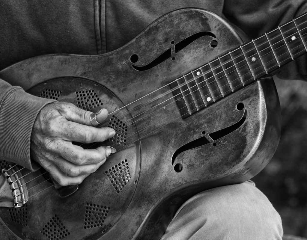 A detail picture of a guitar playing man with a metal - guitar. black abd White high contrast picture