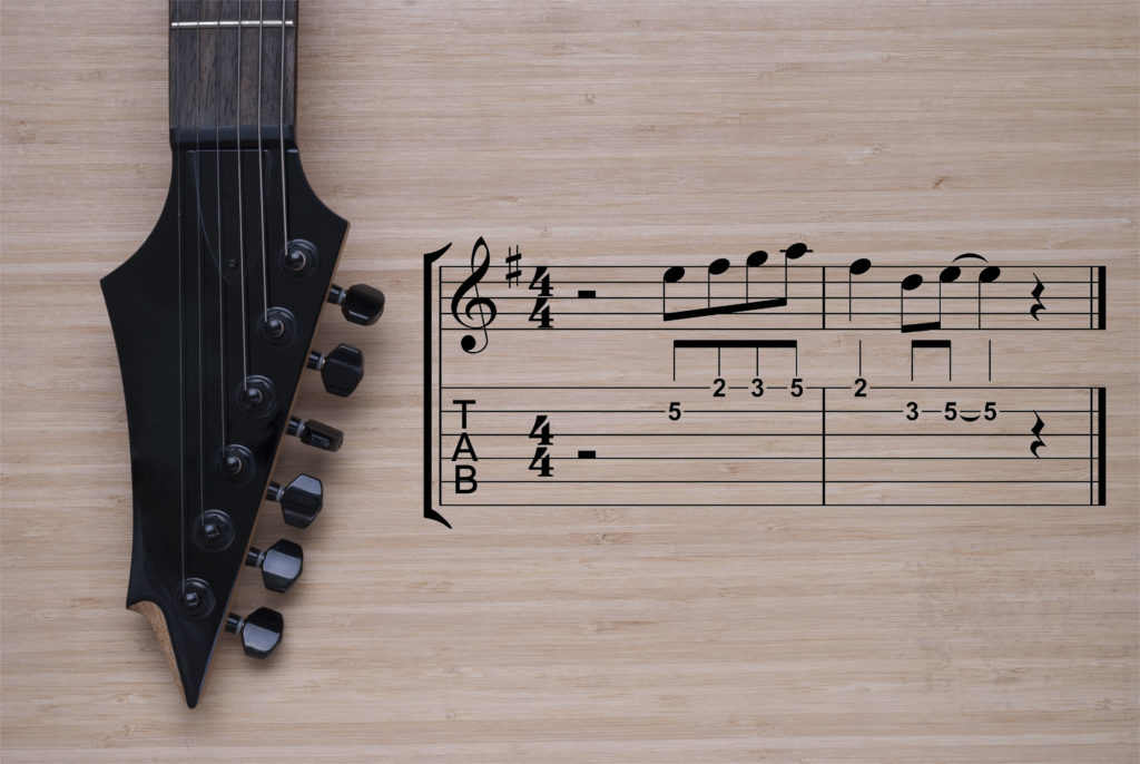 electric guitar fretboard on a wooden background texture